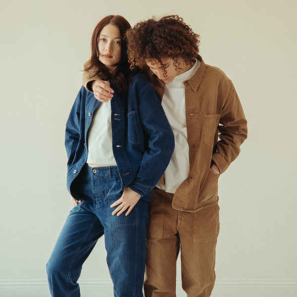 Couple wearing Canoe Club x OrSlow 40’s Coverall Jacket and Regular Fit Fatigue Pants